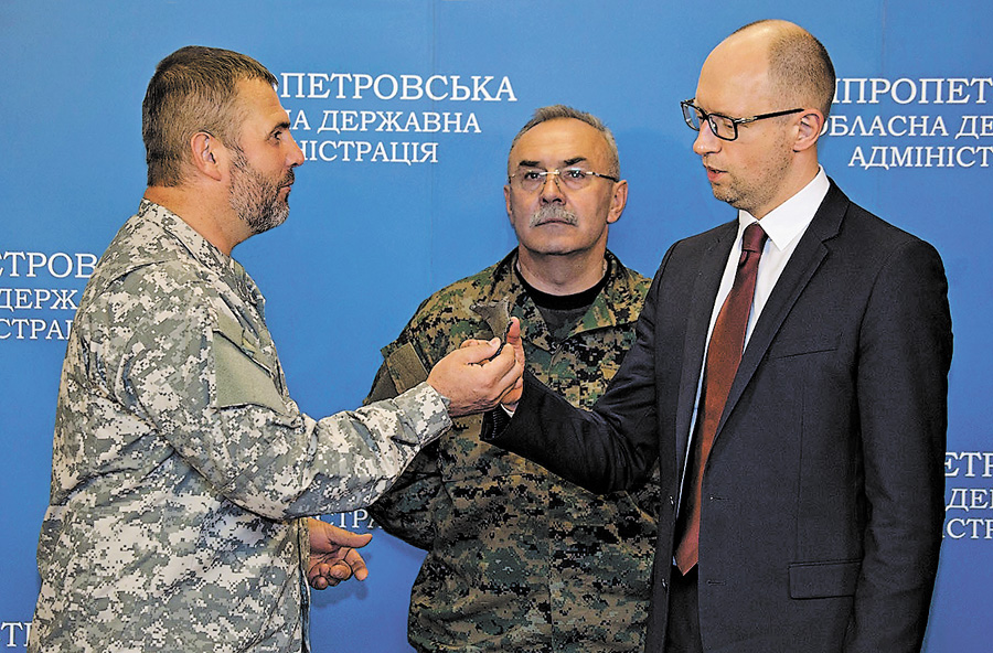 Командир добровольчого батальйону «Дніпро-1» Юрій Береза подарував Арсенію Яценюку осколок від снаряда «Града» із зони АТО. Фото з Урядового порталу